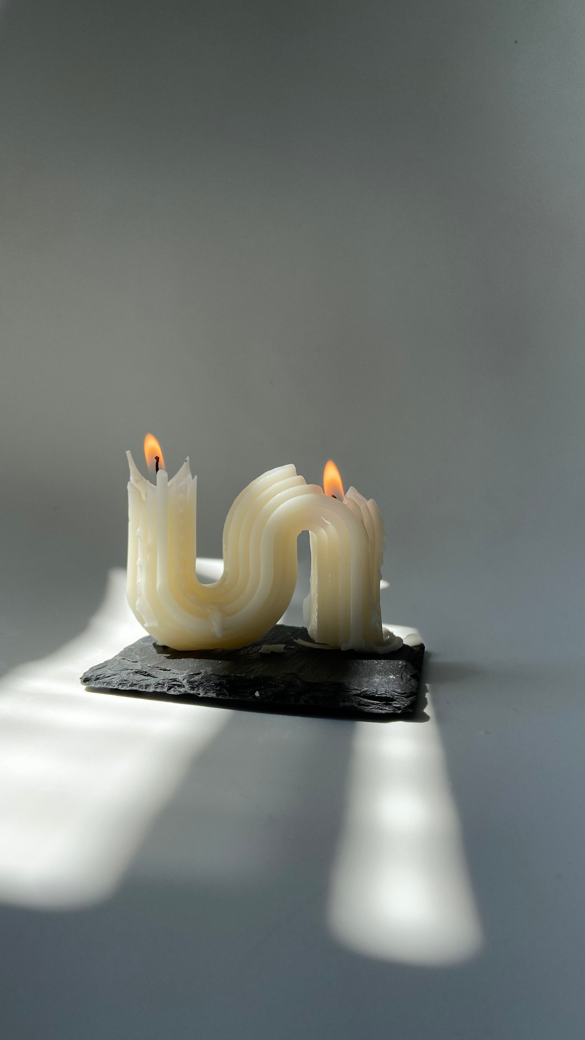 A picture of the ivory colour  s-shaped candle burning